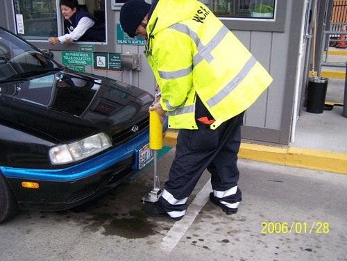 A state ferry worker measures vehicle length using WSF's new laser-equipped measuring device.