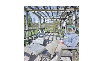 Brent Charnley sits on the patio over looking the Lopez Island Vineyards.