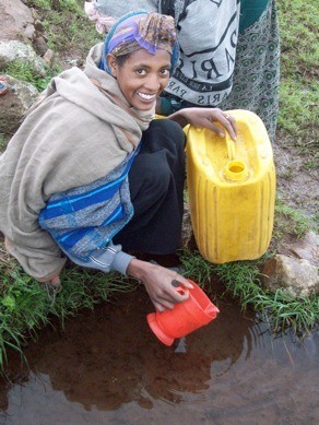 A women retrieves water in a small village in Kenya