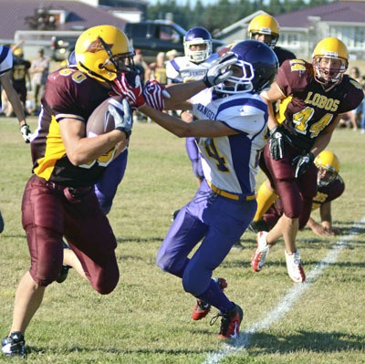 Edwin Kramer (#60) straight-arms a would-be Quilcene tackler on the way to a Lopez score while Jaise Poole (#44) admires his technique. Lopez defeated Quilcene 50-22 for their second win of the 2012 season.