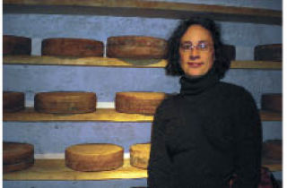 Contributed  photo Kim Bast poses with the wall of cheese at Terra Madre