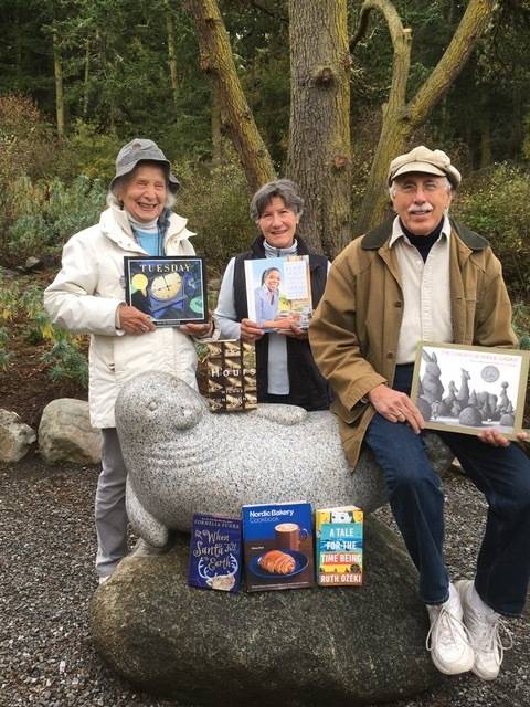 Contributed photo                                Book Sale Lovers Sandy Elliott and Cliff Deem with Friends of the Lopez Library Vice President Taya Higgins and the Library Seal show a few Holiday treasures to be found at the Lopez Library November 24 Book Sale, Library Community Meeting Room.