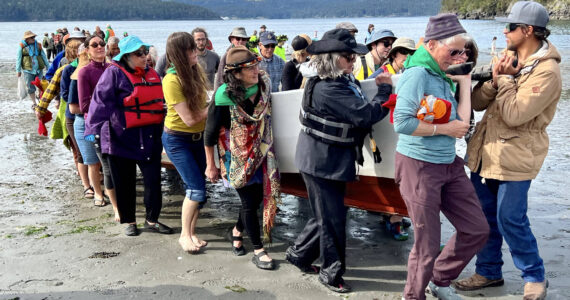 Contributed photo Lopez Friends of Canoe Landings
Volunteers help carry a canoe up the Odlin Park beach during the May 2022 canoe journey.