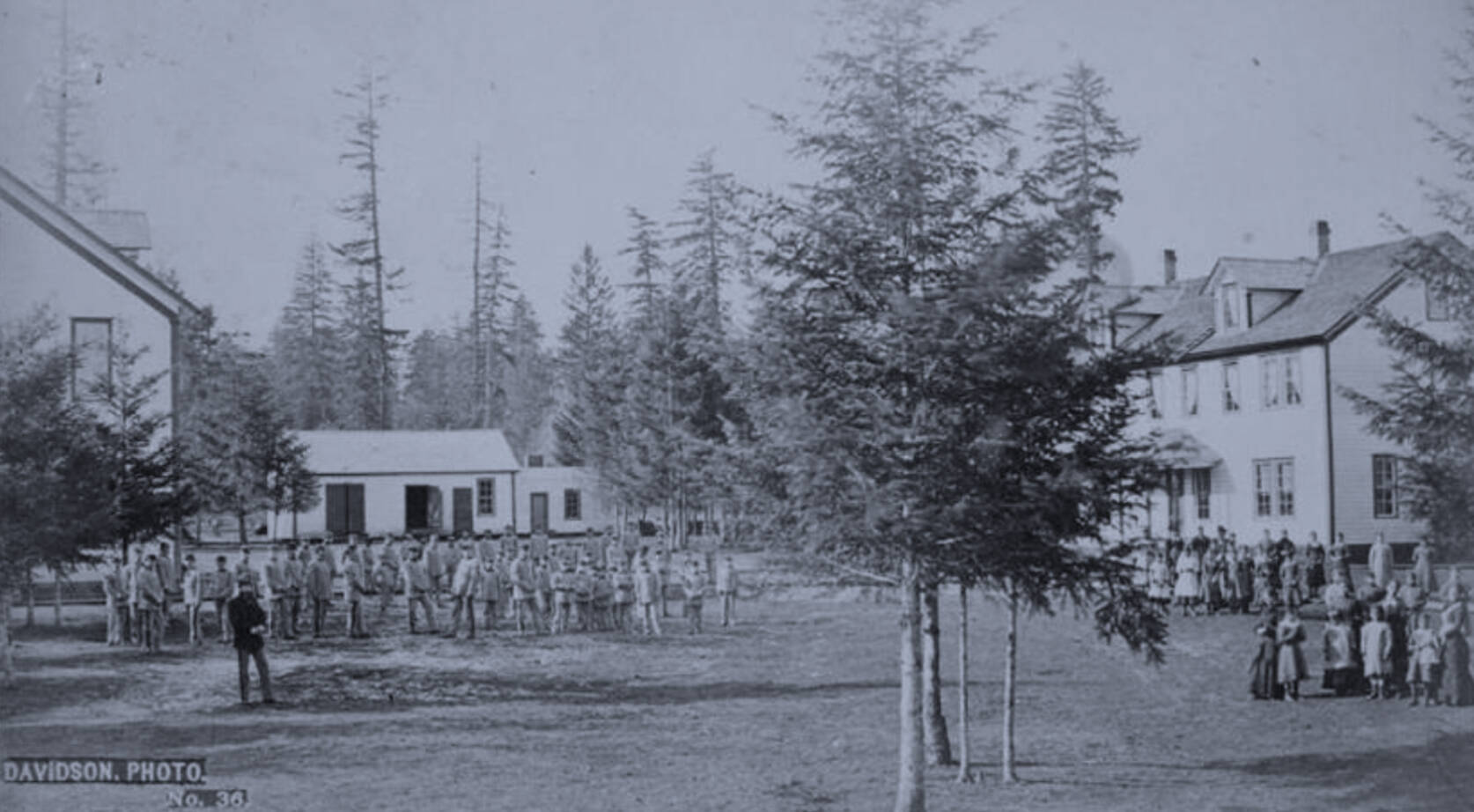 Students in cadet uniforms in front of the buildings, Indian training school, Forest Grove, Oregon,” (1882) taken from Federal Indian Boarding School Initiative Investigative Report, Volume 2.