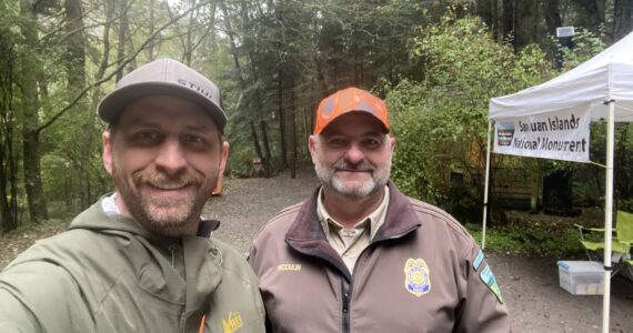 WDFW district biologist Kurt Licence and BLM staff at the kiosk near Watmough Bay on southern Lopez Island.