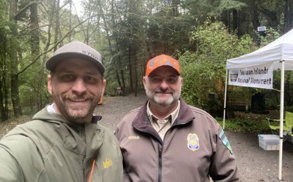 WDFW district biologist Kurt Licence and BLM staff at the kiosk near Watmough Bay on southern Lopez Island.